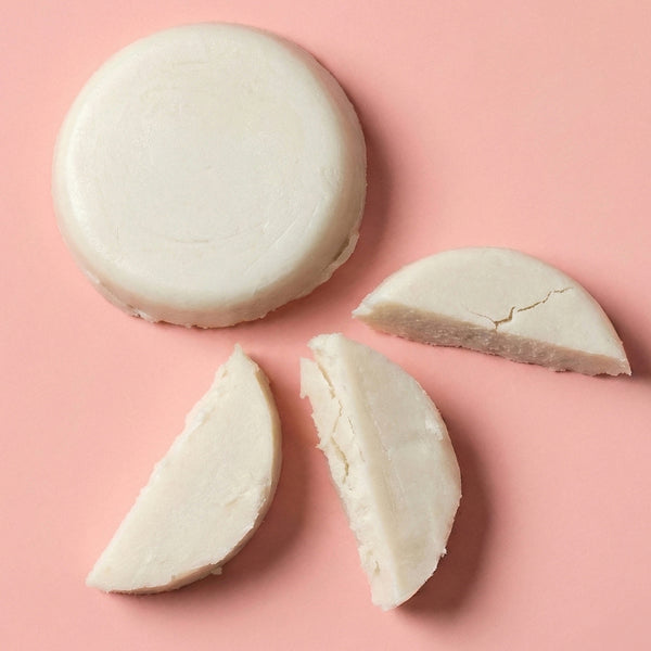 Discs of white frank body Caffeine Deodorant on a pink background.
